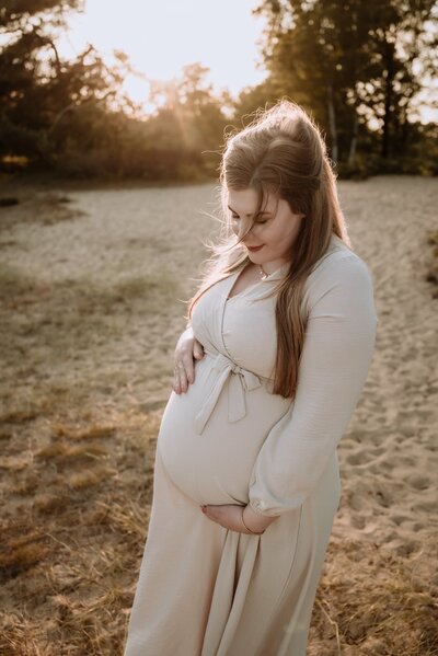 Gezin tijdens zwangerschap fotoshoot tijdens golden hour op heide