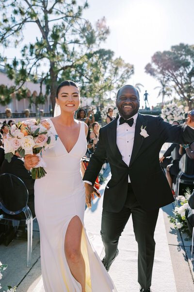 Bride and groom walking down the aisle in outdoor ceremony