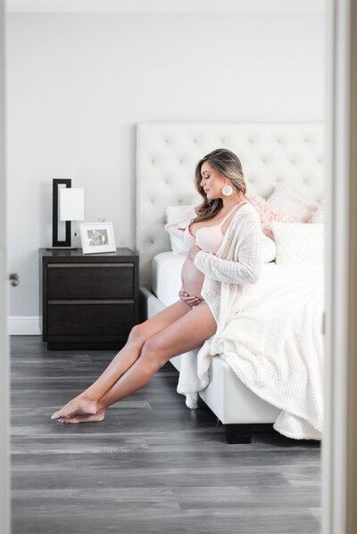 mom holding her belly in home maternity session bedroom miami maternity photographer msp photography David and Meivys Suarez