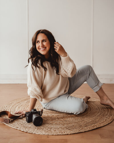 Event planner in cozy winter outfit and grey beanie smiling in snowy Banff forest – Rocky Mountain Wedding Collective
