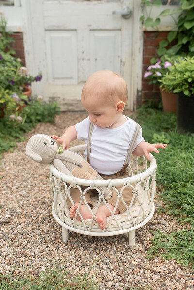 Young boy in white shirt sitting in white crib