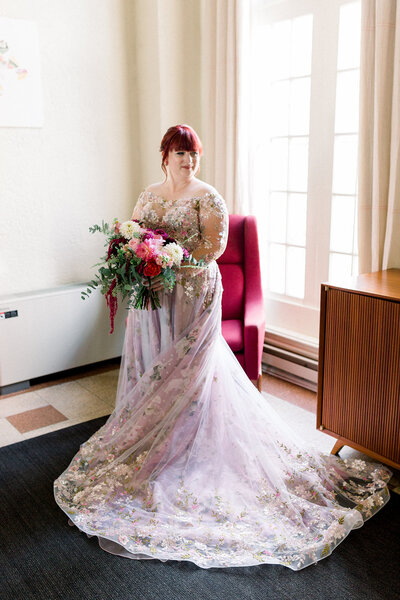 bride with flowers in front of window