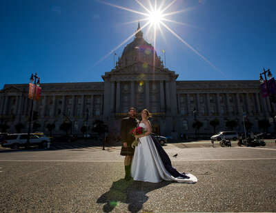 Bride and groom standing in front of San Francisco City hall during their Destination Elopement