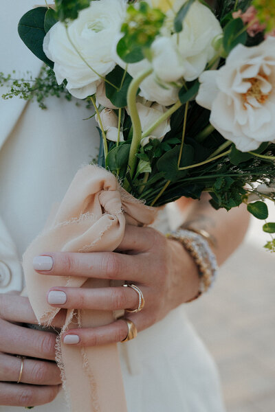 Up close of hands holding a bouquet, representing events planned by Perfect Thirds & Co. 