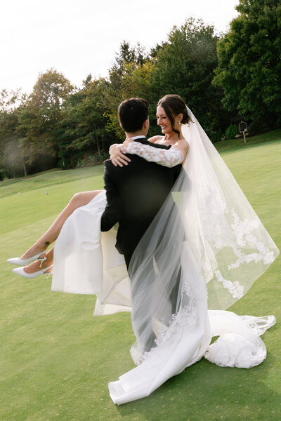 Close up view of a bride in a satin white dress with tattoos on her arms and hands