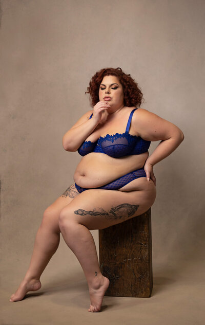 beautiful plus size woman posing in blue lingerie for a boudoir photographer