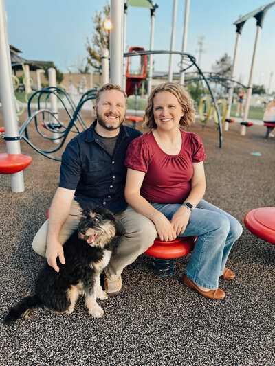 Cornerstone Dog training couple sitting with a dog on a playground