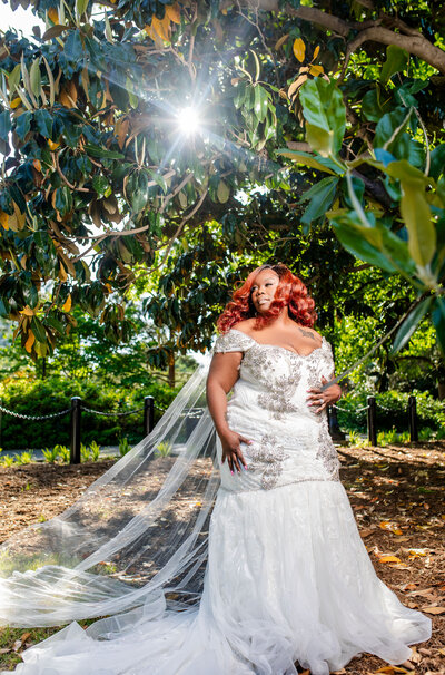 Experience the beauty of bride Courtney, featuring her flowing red natural hair styled by CandyForeverHair and makeup by by Pretty Faces by Chelsea. Captured in a sunburst moment, this image exemplifies elegance and artistry in luxury wedding photography. Perfect for celebrating unique bridal beauty!