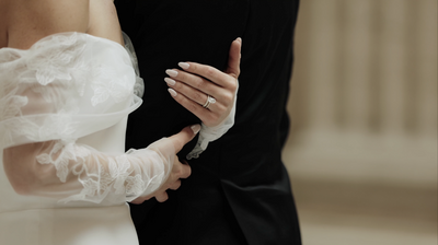 Bride holds on to groom's arm