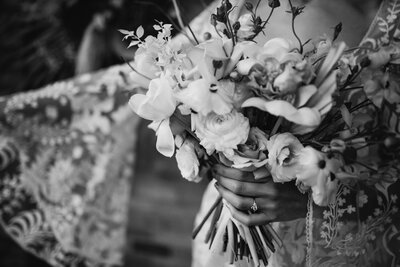 Black and white photo of brides hands holding bouquet