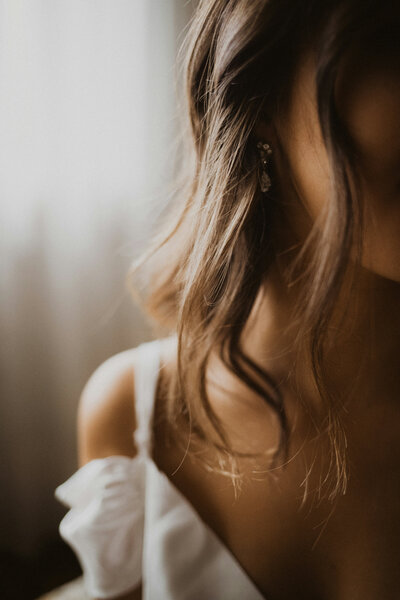 Close up mage of a woman with a white dress and curls