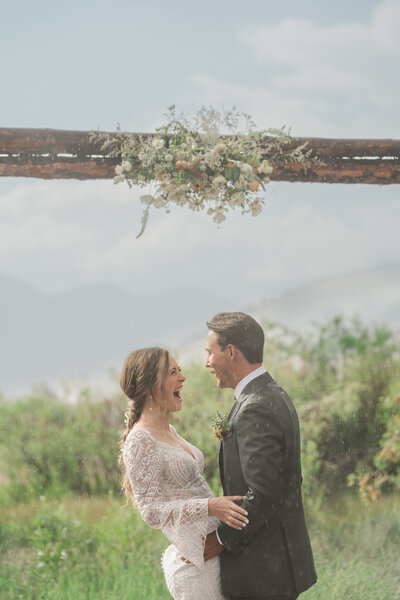 A bride laughs in the rain at her elopement ceremony in Buena Vista