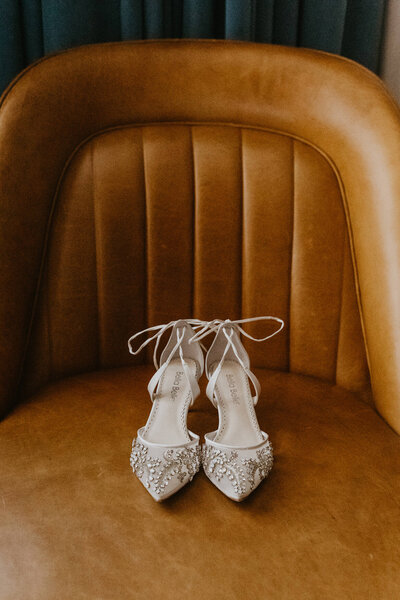 bridal shoes on leather chair