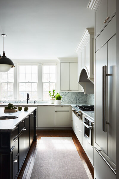 Kitchen and bath design Boston transformed a historic Concord home with a modern white and black kitchen featuring custom cabinetry and striking finishes.