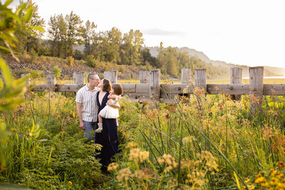 Family standing together in lush greenery near the Columbia River Gorge during a sunset Portland family photography session.