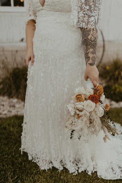 Photo of a bride's lacy skirt with her flower bouquet by her side