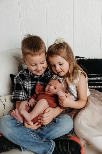 Lubbock family of five standing on a pathway. Dad has the older son on his shoulder, mama is holding baby brother on her hip and sister is standing in front of mom.