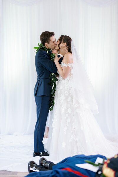 A newlywed couple during their first kiss at their wedding 