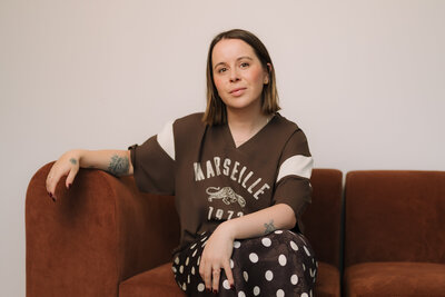 Liv Rollings sitting on a rust colored couch