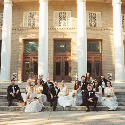 bridal party sitting in front of venue by 35mm film wedding photographer Noble Photo Co