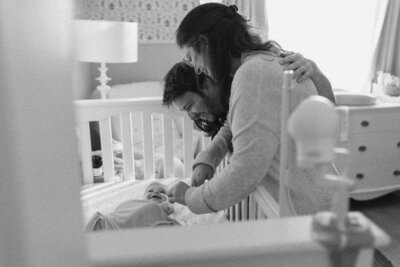 Mother and father looking at baby in crib at Austin family photo session