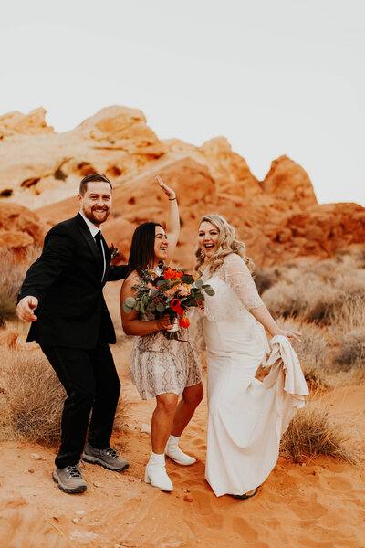 Bride and groom picture with photographer dancing in the desert