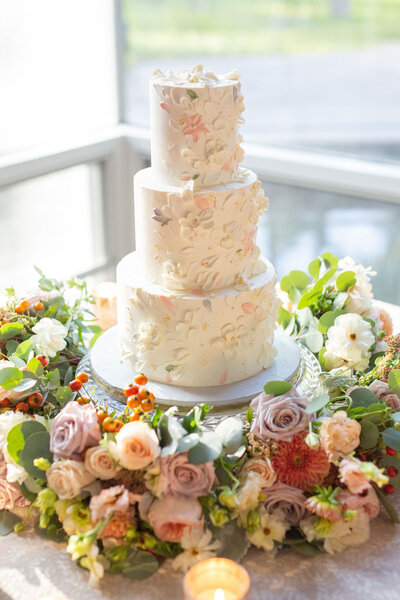 wedding cake surrounded by florals