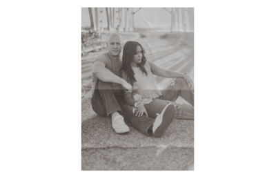 husband and wife sitting on bridge