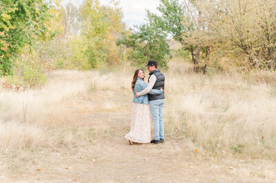 a couple posing for a portrait in a fall landscape with their arms around each other in lewiston idaho