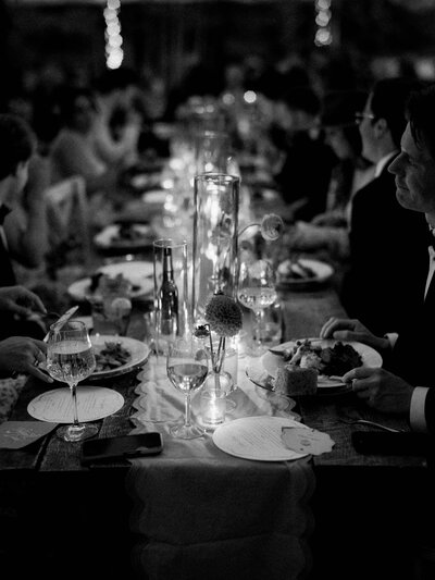 a table full of flowers with a brown barn behind in a field by colorado wedding photographer JKG photography