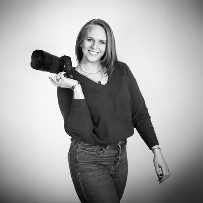 wedding photographer Courtney holding camera and smiling