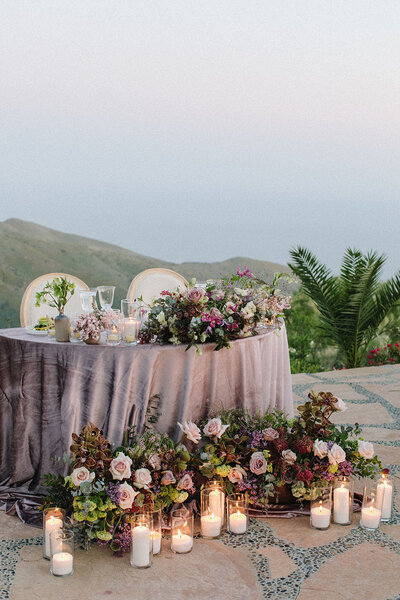 Romantic sweetheart table with purple velvet linens, purple ombre flowers, and candles at Malibu Dream Resort!