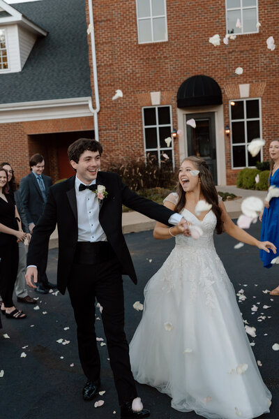 Bride walks up a hill while holding colorful bouquet of flowers