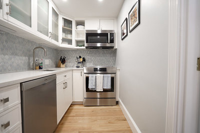Renovated Kitchen with White cabinets and blue backsplash