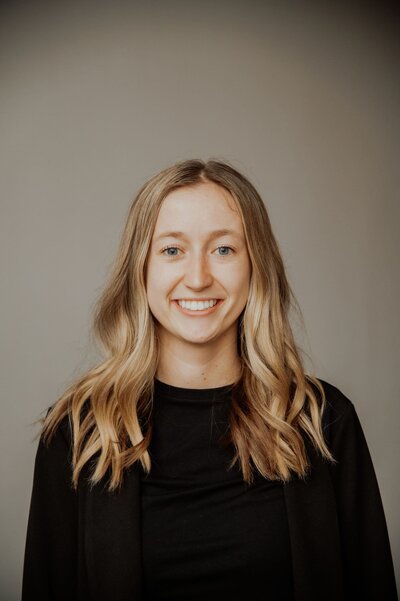 Hailey James smiling in black sweater