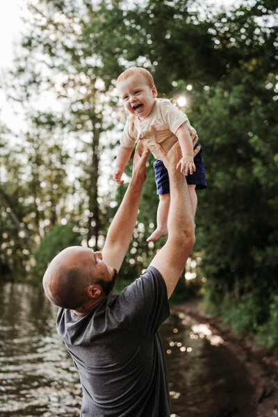 father throwing son in the air smiling