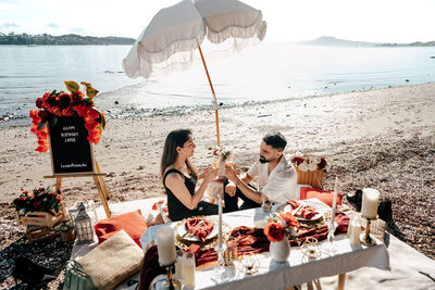 Romantic beachside picnic proposal with Harleen and Jayse in Auckland, photographed by Zanthe Vorsatz.