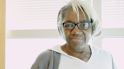 Woman with slight smile wearing glasses