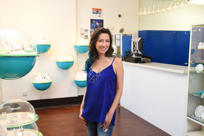 small business owner in blue top standing  in her shop