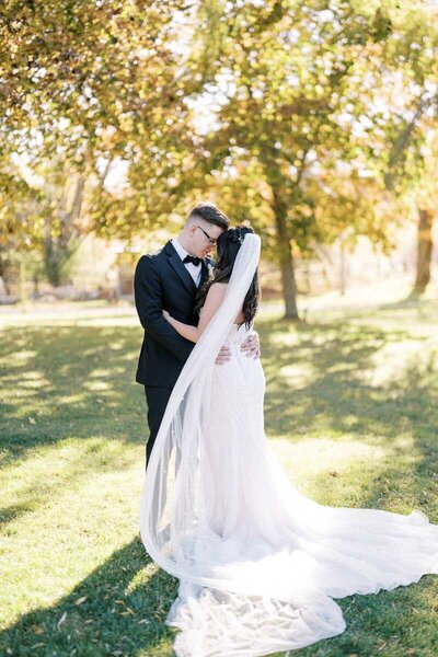 Bride and groom embracing under golden autumn trees at Caledon Valley Estate, wedding captured near Toronto