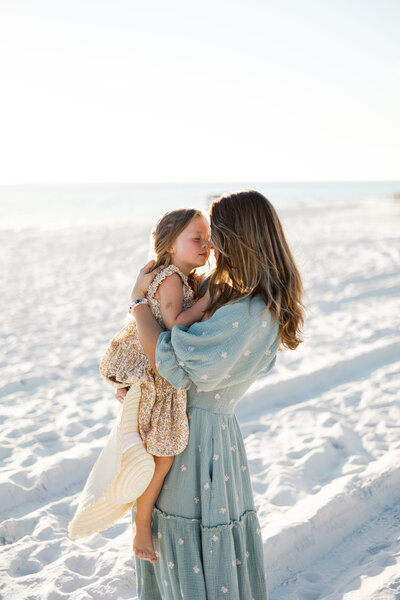 Mom and daughter embrace with a sun-kissed beach session in Argyle, Texas.