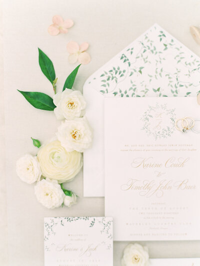 romantic white invitation suite flatlay with hand drawn greenery monogram and envelope liner