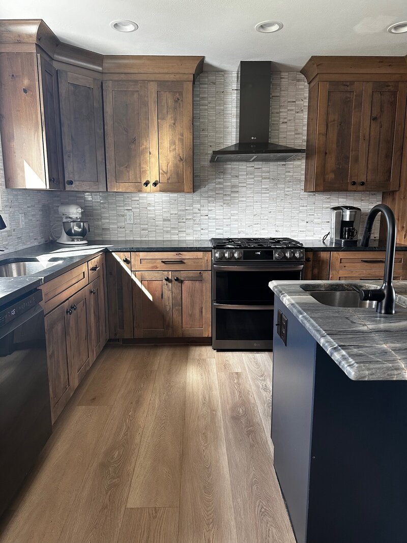 Kitchen with marble countertops, dramatic light fixtures and a deep blue island