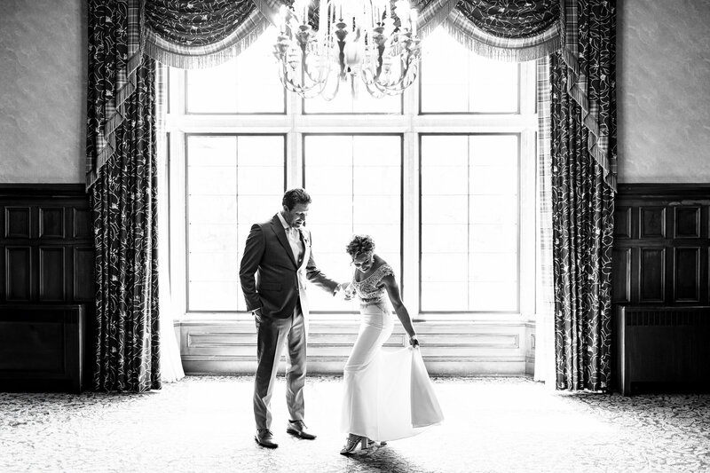 A wedding couple standing in front of a large window at the Sylvania Country Club in Ohio