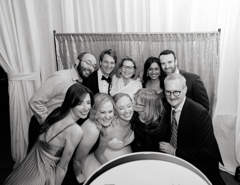 November wedding at Graylyn Estate, designed and planned by Charming Carolina — bride and groom taking a photo surrounded by friends at their reception photo booth.