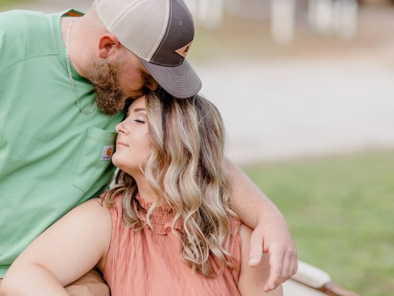 A future  groom kissing his future bride on  her forehead at their engagement session with Salina Korn Photography.