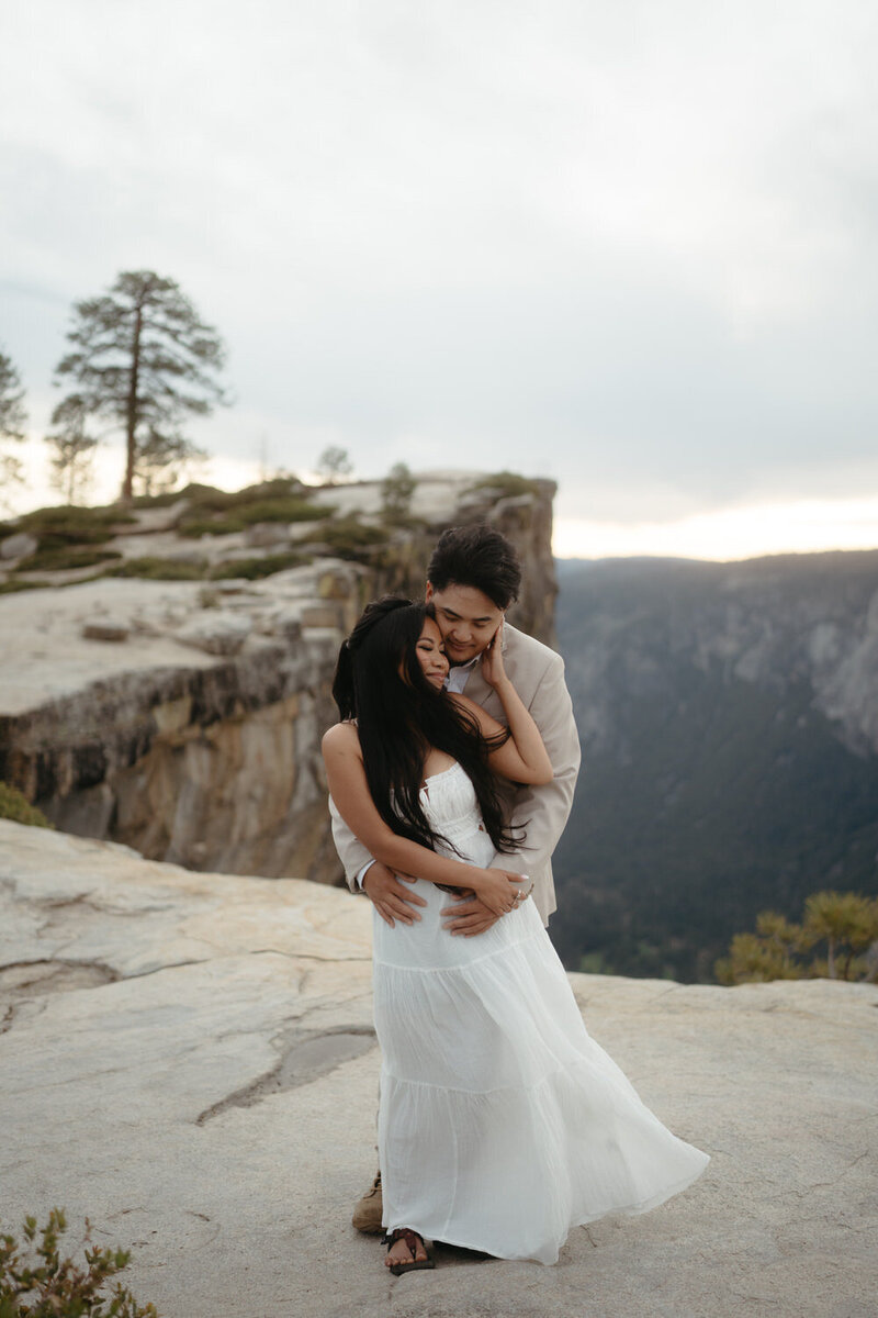 Yosemite Elopement - groom stands behind bride as she smiles into the distance 