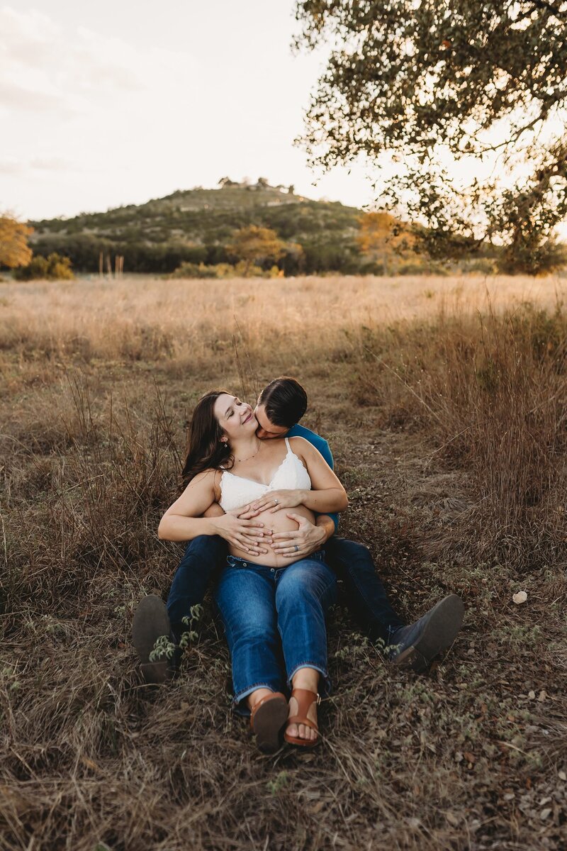 Pregnant woman and husband sitting on the grass