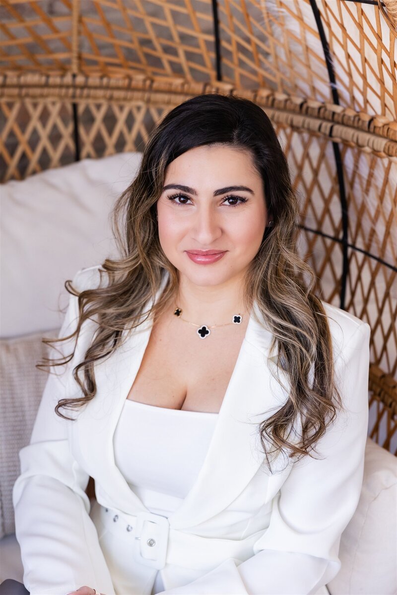 Yudielis Sánchez sentada  con suit blanco.