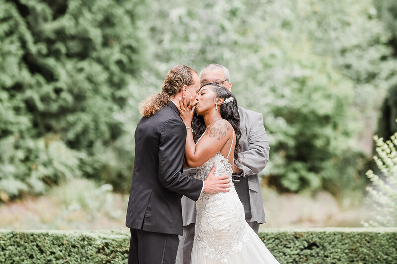 man and woman kissing at aisle at Rock Creek Gardens Wedding Venue in Puyallup, Washington. Seattle Wedding Photogrpaher captured this moment.